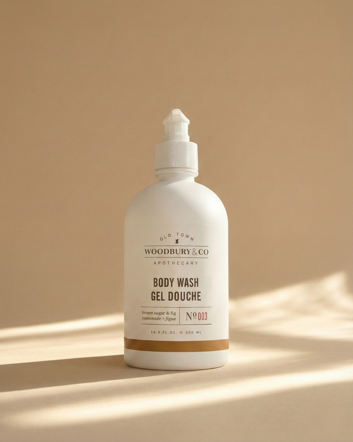 White bottle of Woodbury & Co. body wash on a beige background
