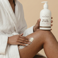 Person applying lotion to their leg with a bottle of Woodbury & Co. lotion.