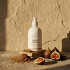 Shampoo bottle with figs on a stone surface