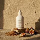 Shampoo bottle with figs on a stone surface