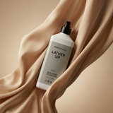 Kenny Cole Lather Up body wash bottle on beige fabric