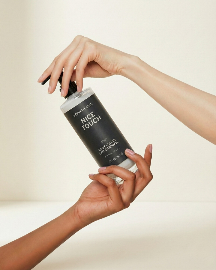 Hand holding a bottle labeled 'Nice Touch' against a neutral background