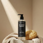 Hand wash bottle labeled 'In Good Hands' by Kenneth Cole on a beige surface with a towel and sponge.