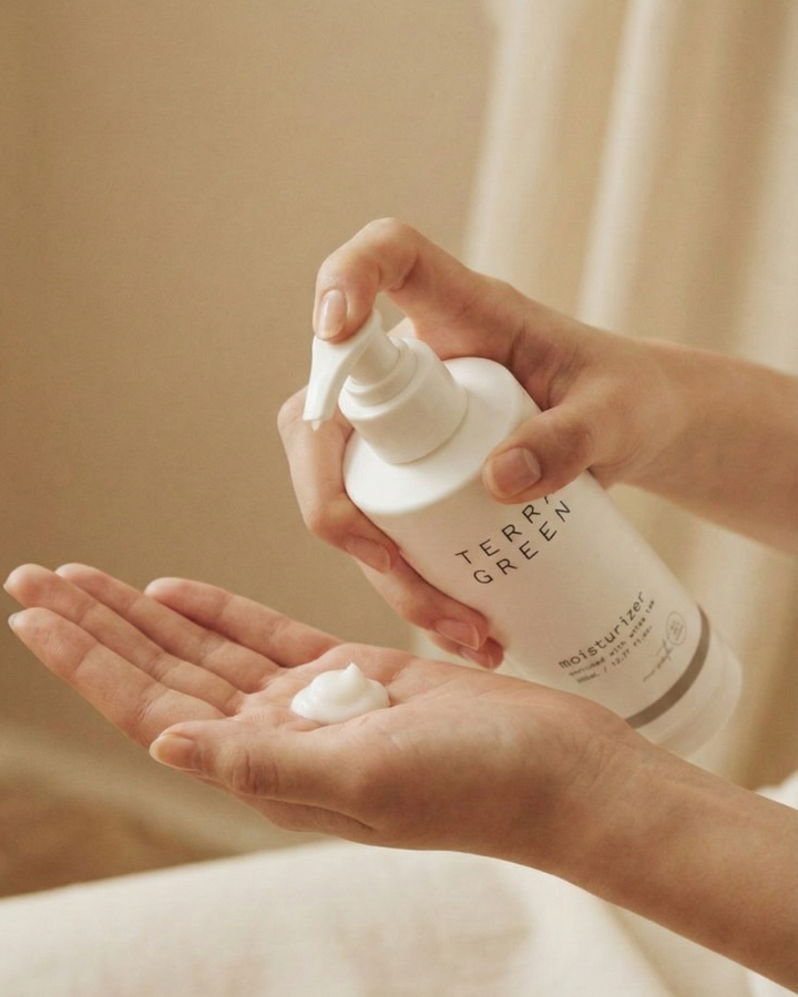 Person holding a bottle of Terra Green product with foam on palm