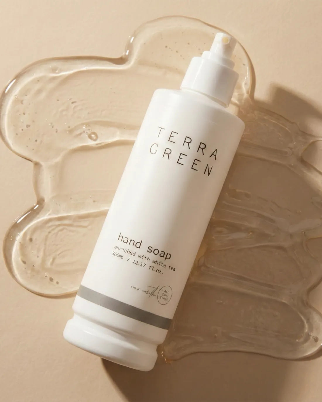 Terra Green hand soap bottle on a soft cream background