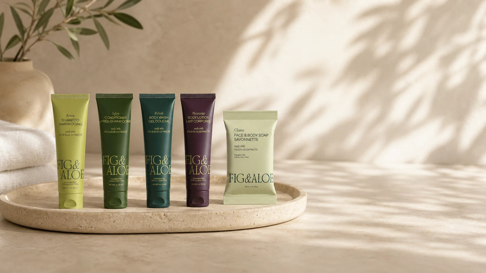 Fig and Aloe guest-size tubes and wrapped soap on a travertine tray