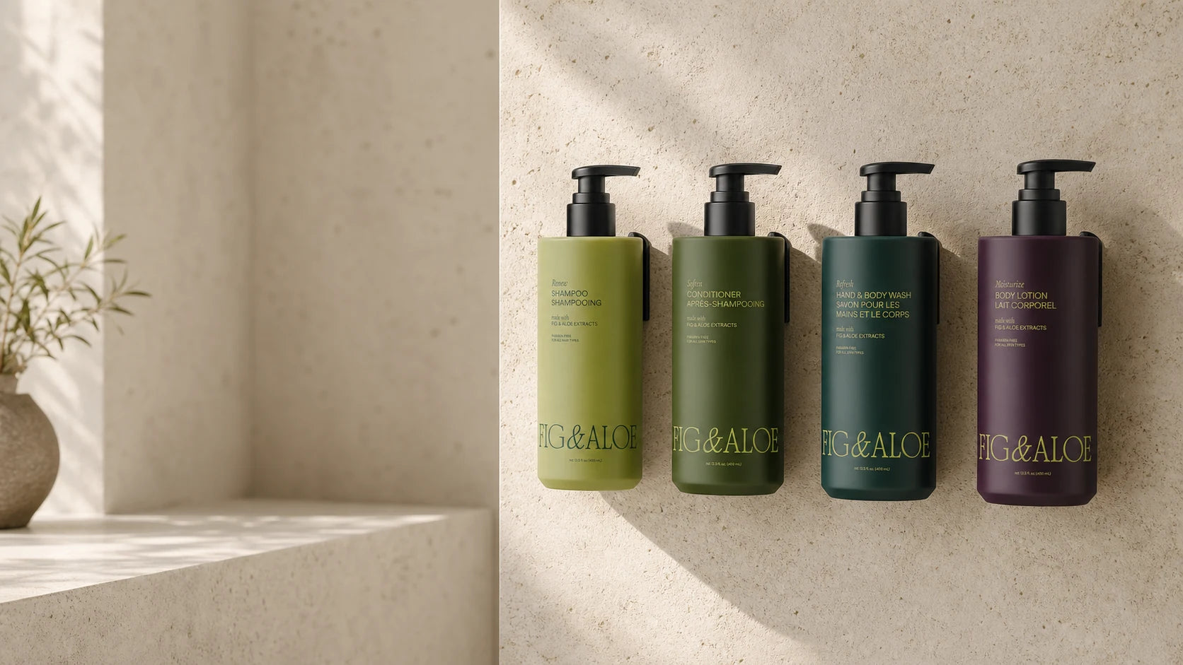 Four Fig and Aloe Stratus dispensers mounted on a limestone hotel bathroom wall